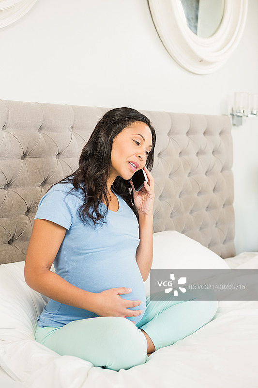 怀孕的黑发女人在打电话图片素材