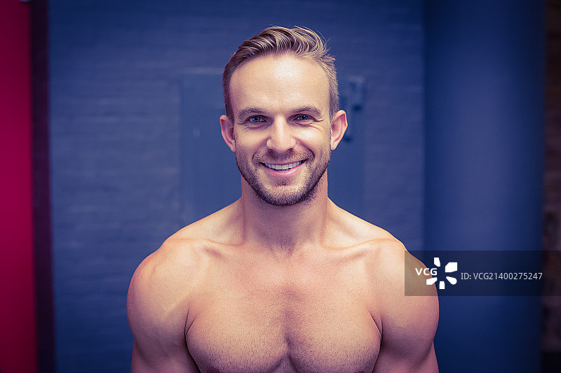 一个在健身房微笑的肌肉男的肖像图片素材