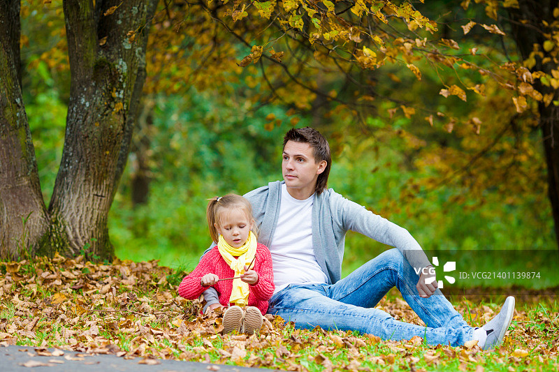 可爱的小女孩和爸爸在美丽的秋天公园户外图片素材