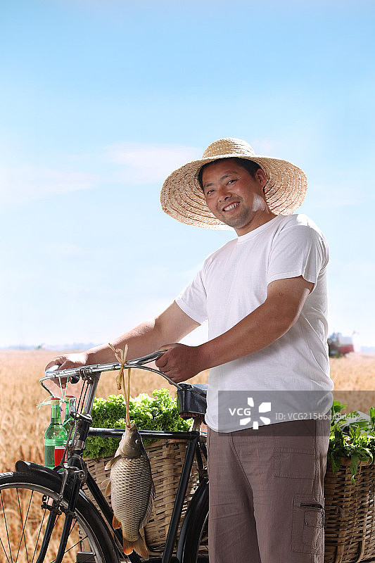 一个农民站在麦田里图片素材