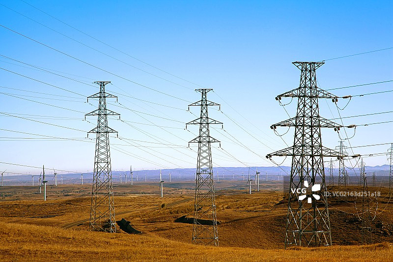 秋天中国丘陵地带高大的输电塔和成片的风力发电车图片素材
