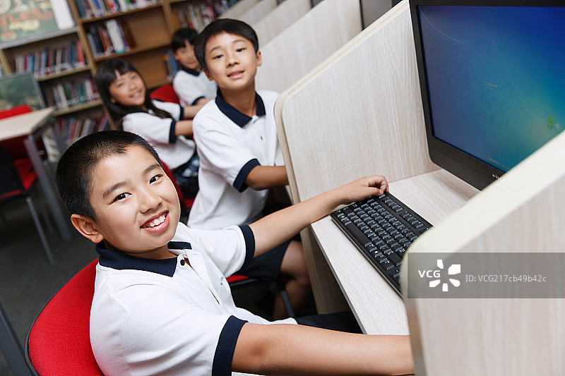 小学生在阅览室里使用电脑图片素材
