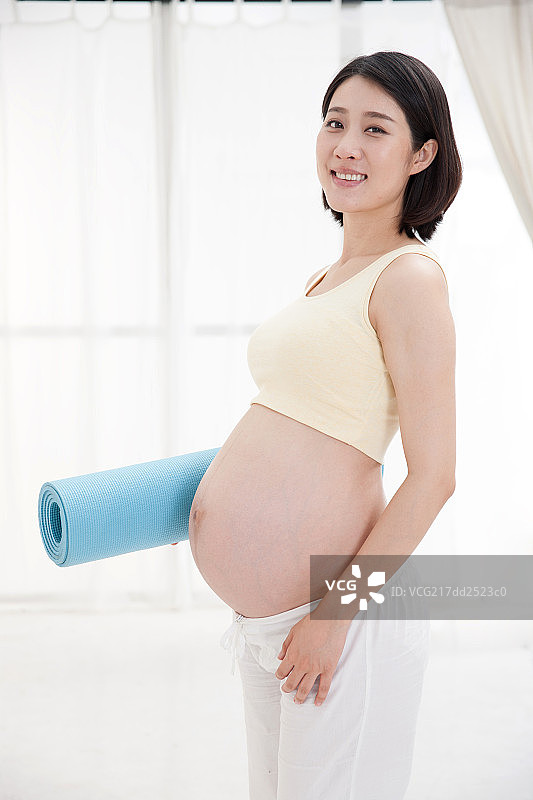 孕妇拿着瑜伽垫图片素材