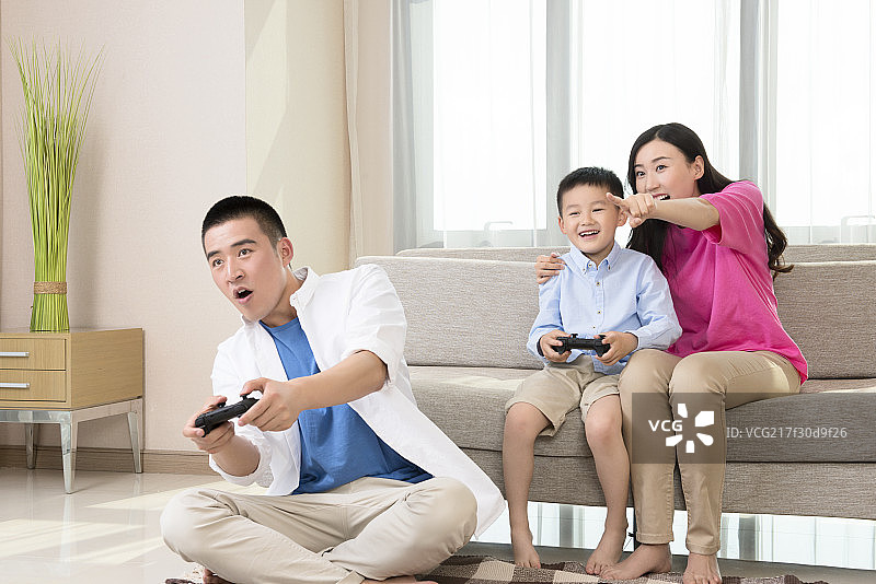 Young family playing video game图片素材
