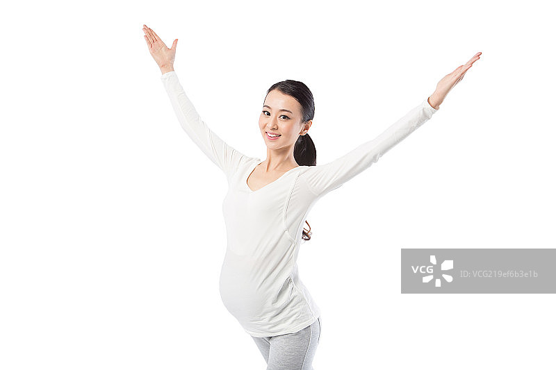 在白色背景下练瑜伽的孕妇图片素材