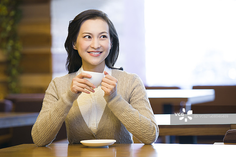 年轻女子在咖啡馆喝咖啡图片素材