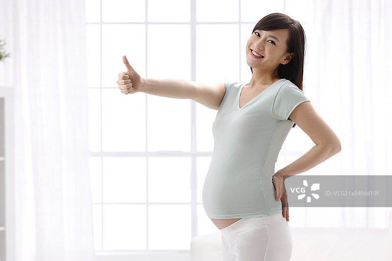 幸福的孕妇竖起大拇指图片素材