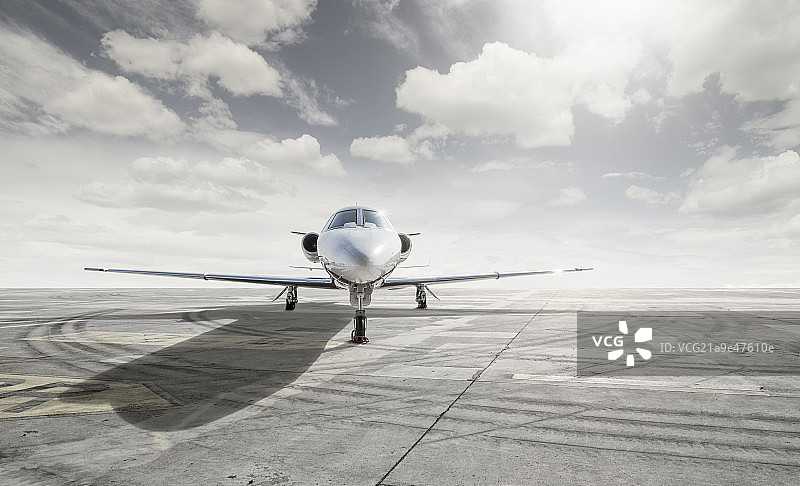 逆光下的私人飞机和机场停机坪轮胎印图片素材