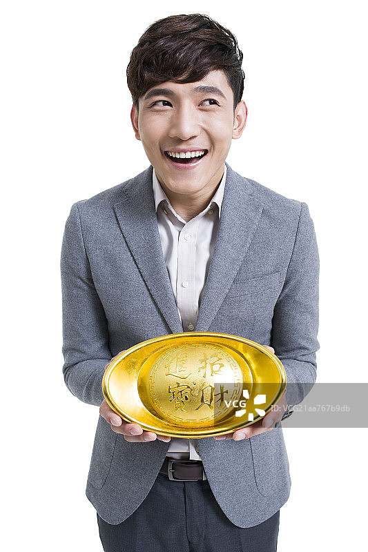 快乐的年轻男子抱着一个金元宝图片素材