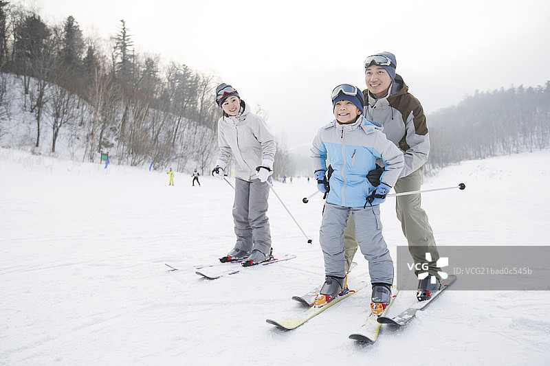 年轻的父母教儿子滑雪图片素材