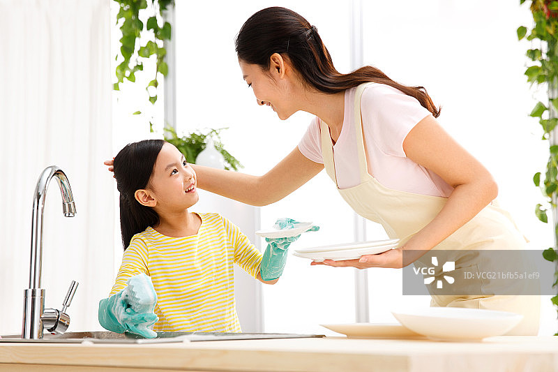 小女孩和母亲在洗餐具图片素材