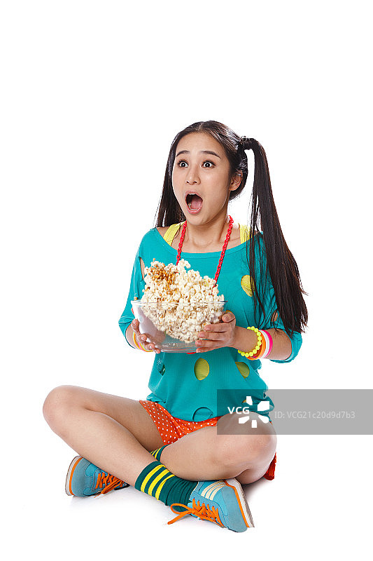 青春活力的年轻女孩吃爆米花图片素材