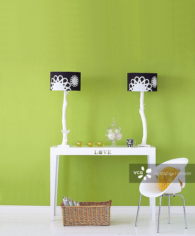 两盏黑色和白色灯罩的台灯在桌子和儿童的椅子前，绿色油漆的墙图片素材