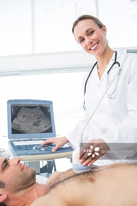 自信的女医生在检查室用超声波扫描男性病人图片素材