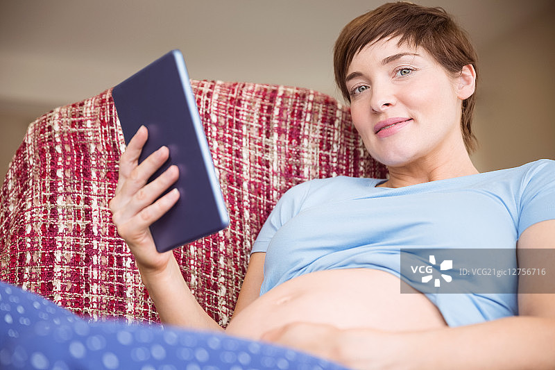 孕妇在客厅里使用平板电脑图片素材