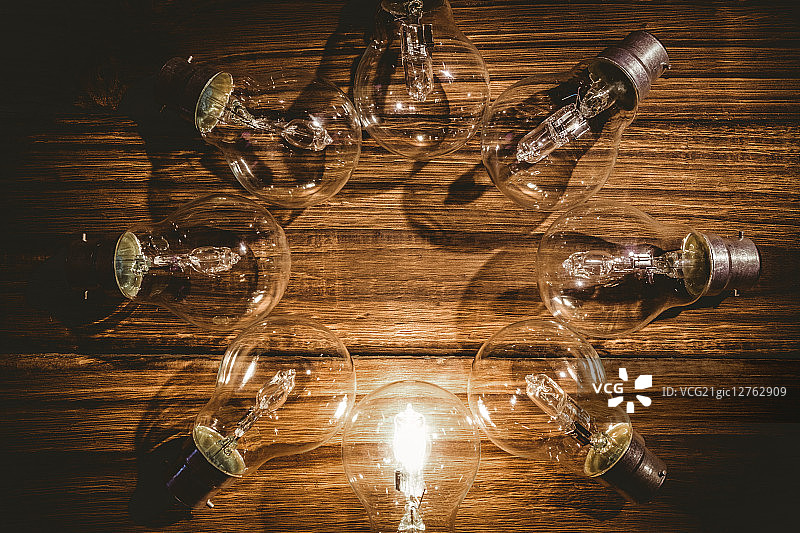 灯泡在木桌上形成框架图片素材