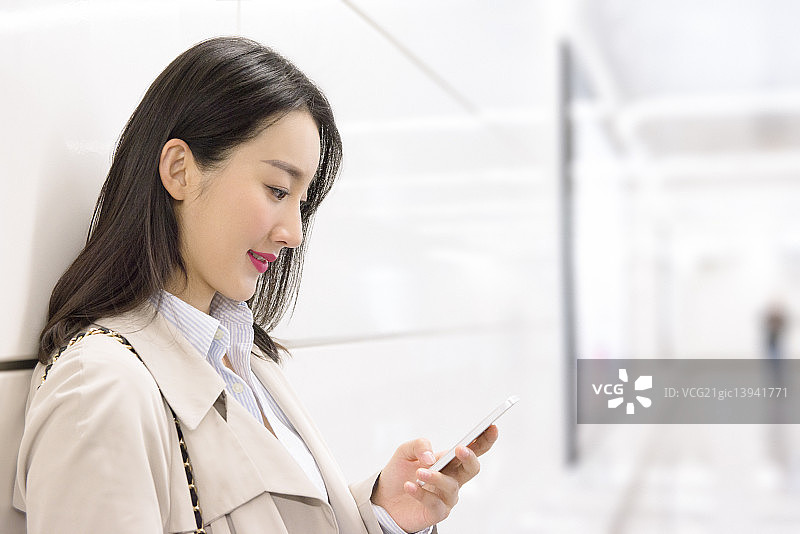 Businesswoman using smart phone at underground station图片素材