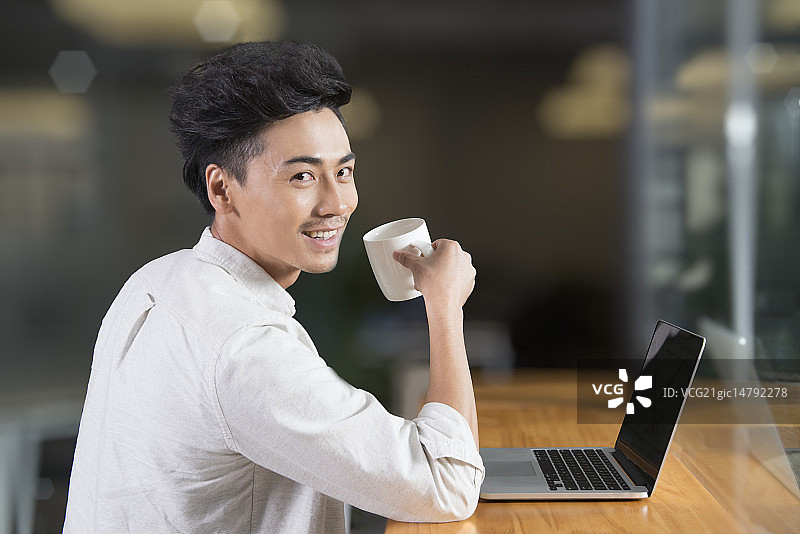 Creative businessman using laptop in break room图片素材