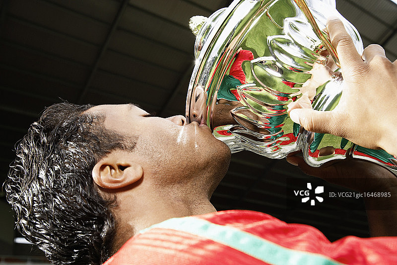 足球运动员亲吻奖杯图片素材