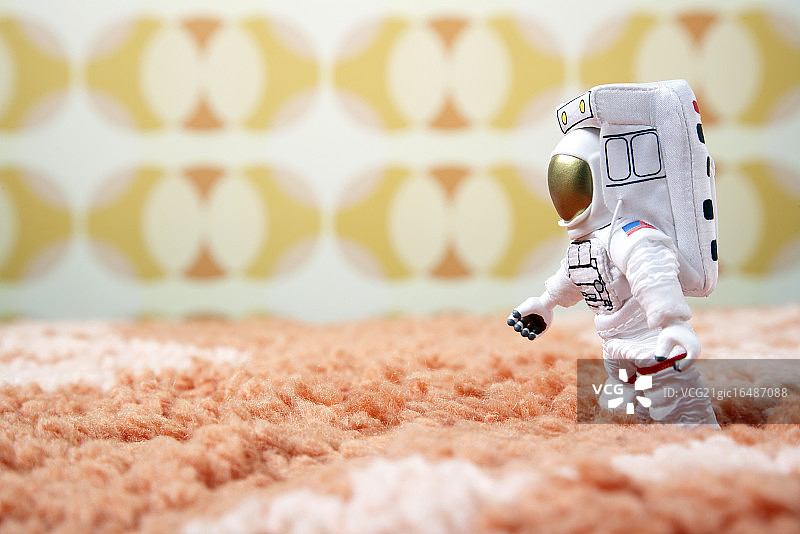 玩具宇航员在粗毛地毯上行走图片素材