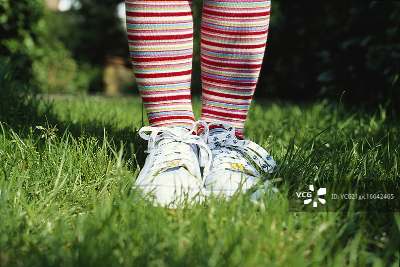 小女孩穿着条纹紧身衣和运动鞋图片素材