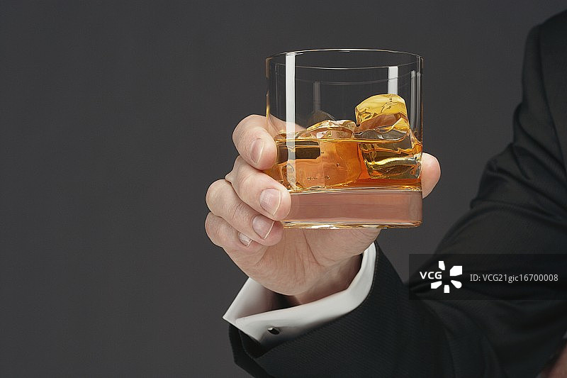 拿着一大杯苏格兰威士忌的男人图片素材