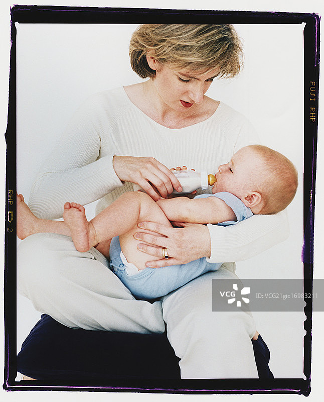 妇女用奶瓶喂婴儿图片素材