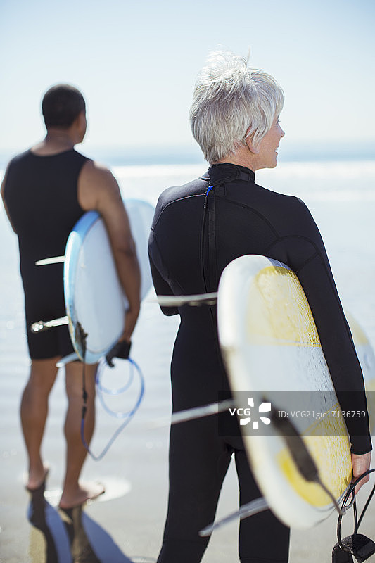在海滩上拿着冲浪板的老夫妇图片素材