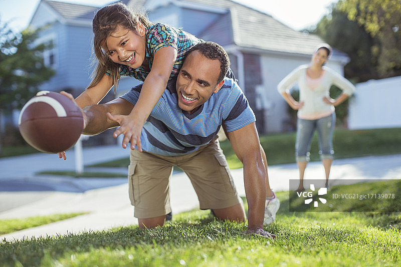 爸爸和女儿在院子里踢足球图片素材