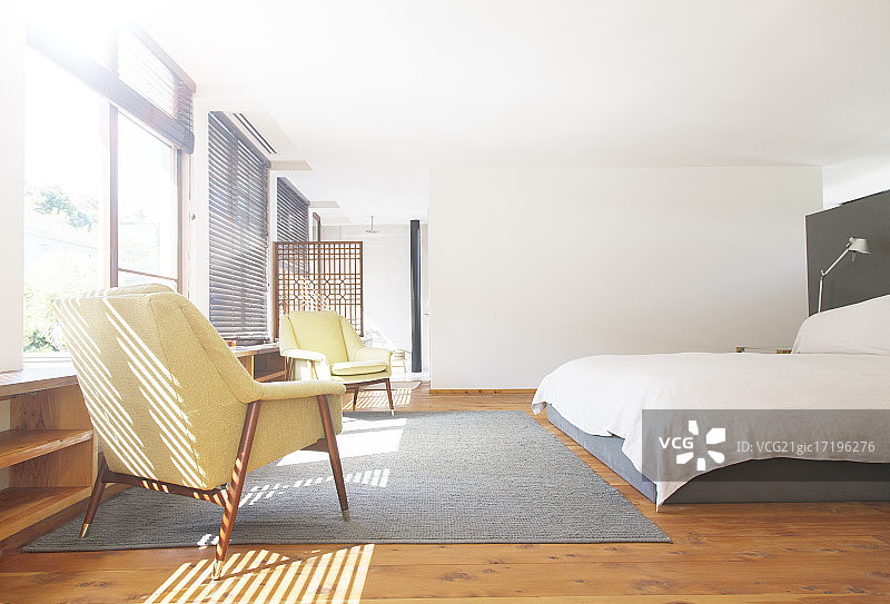 现代卧室里的扶手椅、地毯和床图片素材