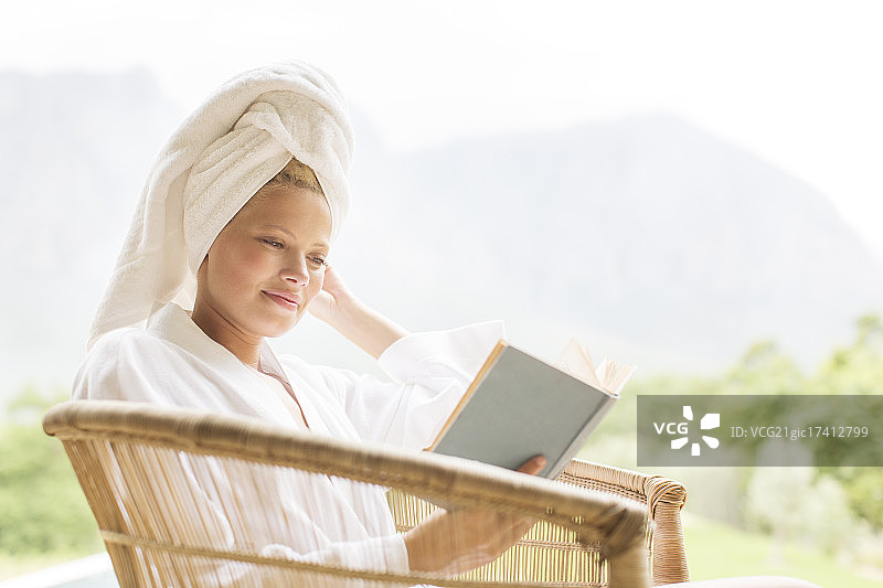 穿着浴袍在户外阅读的女人图片素材