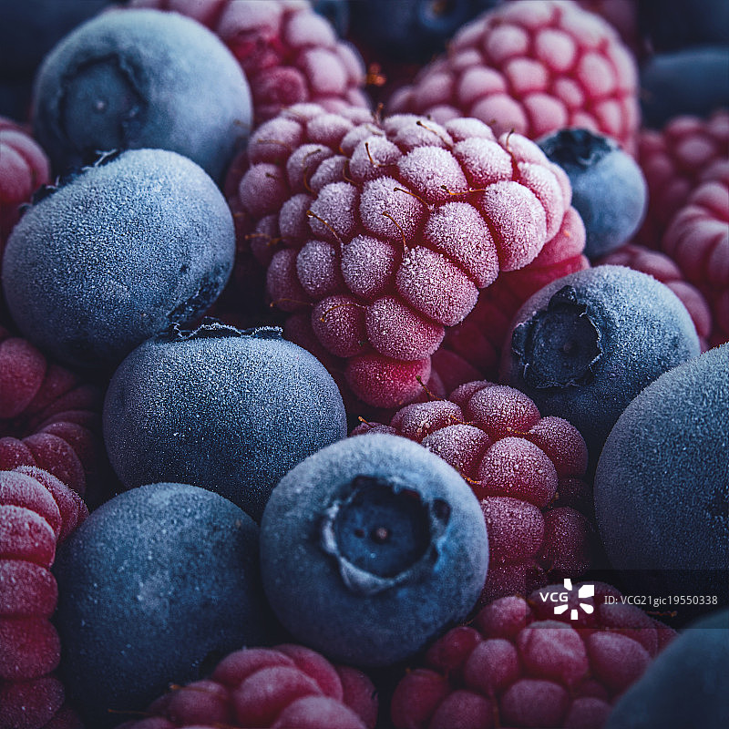 冰冻蓝莓和覆盆子的特写。图片素材
