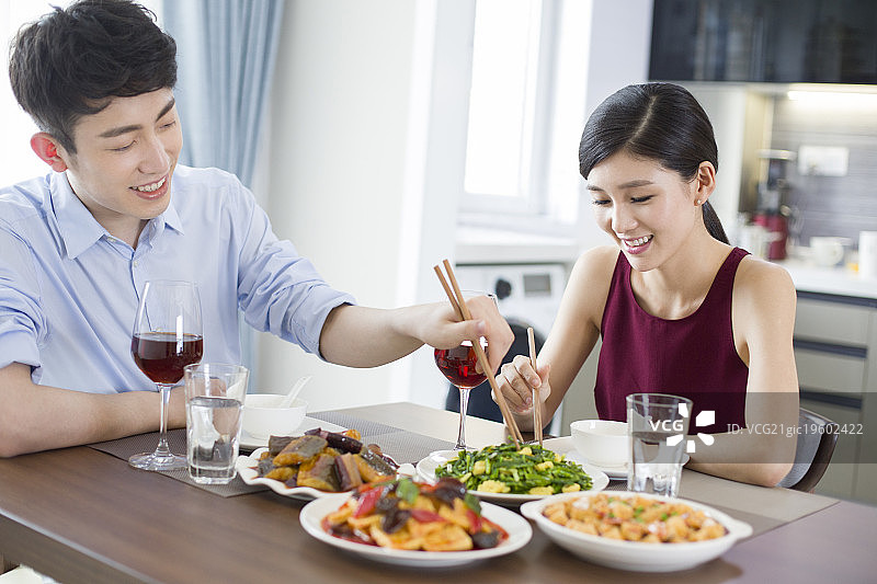 年轻夫妇在家喝红酒吃午餐图片素材