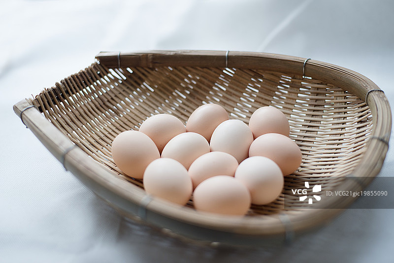 Studio shot of eggs in woven basket图片素材