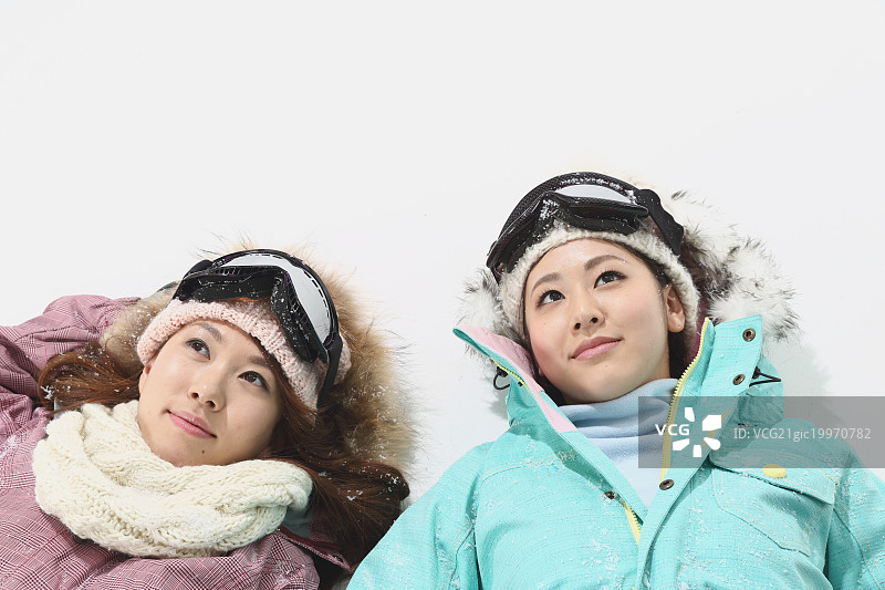 年轻的日本女性穿着白色背景的滑雪板图片素材