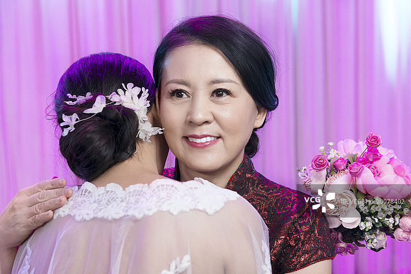 Mother and daughter hugging at wedding图片素材