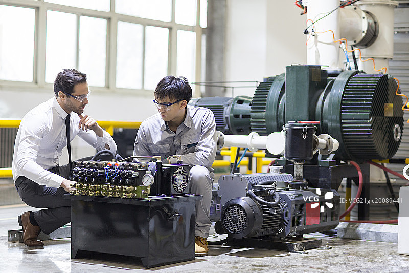商务男士和工程师在工厂检查机器图片素材