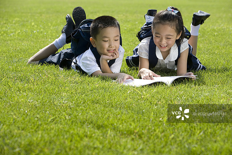 两个在草地上看书的小学生图片素材