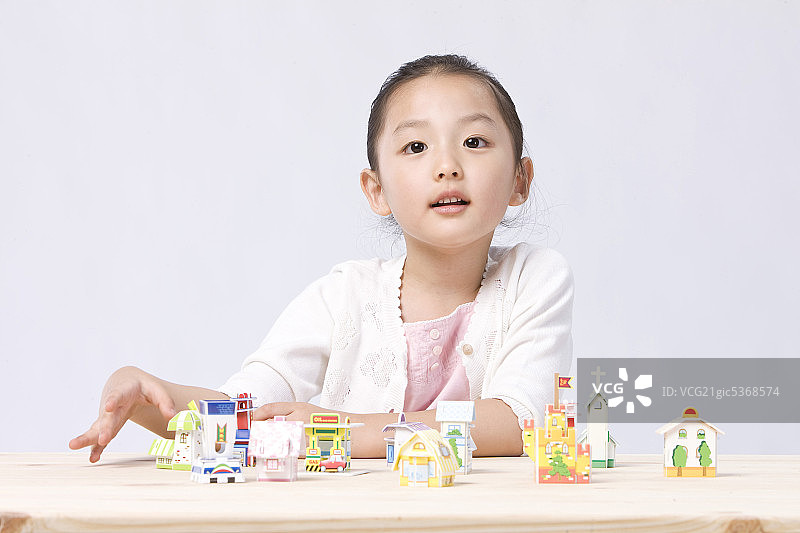 女孩在书桌前玩房子模型图片素材