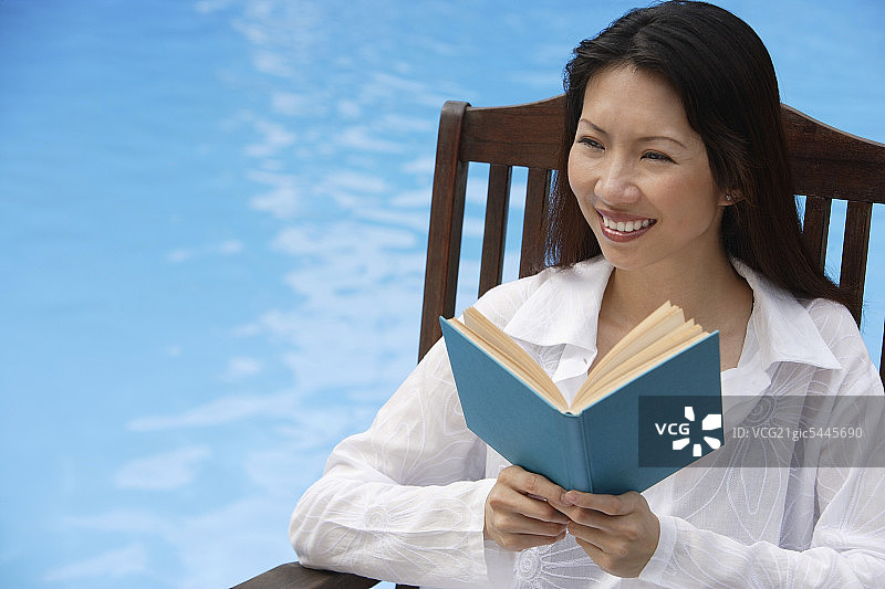 女人在游泳池旁，看书，看别处图片素材