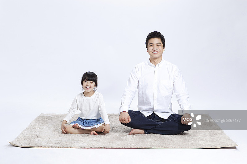 父亲和女儿坐在地毯上图片素材