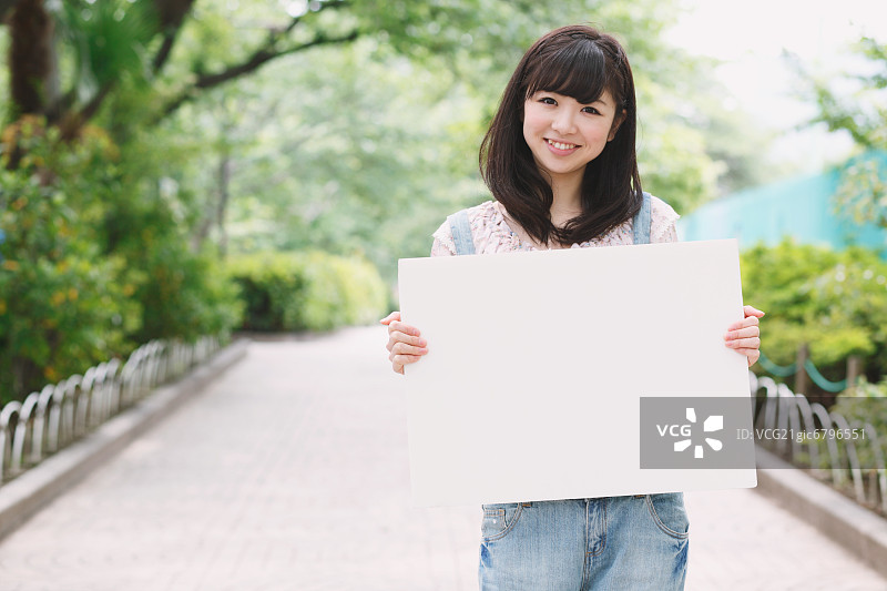 一个日本女孩拿着一块白板图片素材