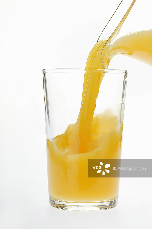 将橙汁倒入果汁杯中图片素材