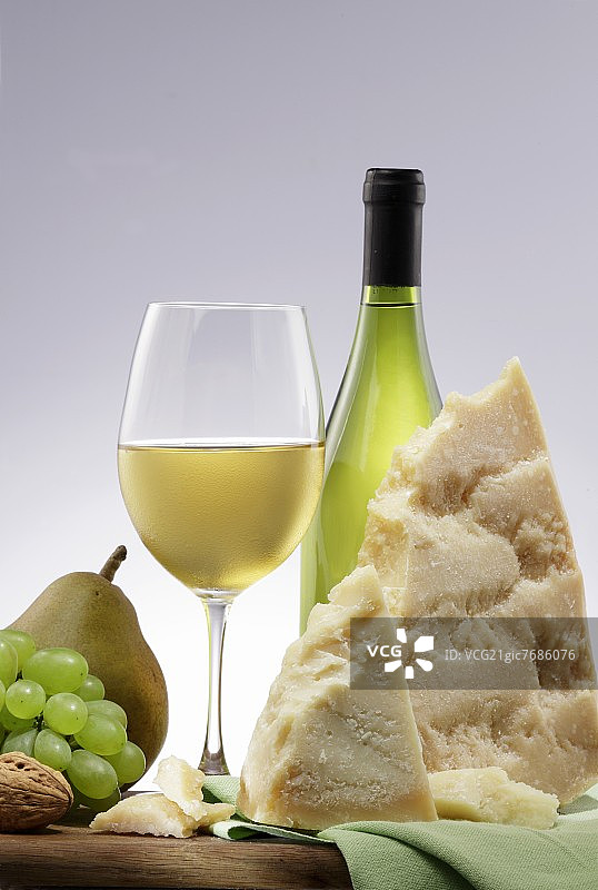 用白葡萄酒、奶酪、水果和坚果排列的菜肴图片素材
