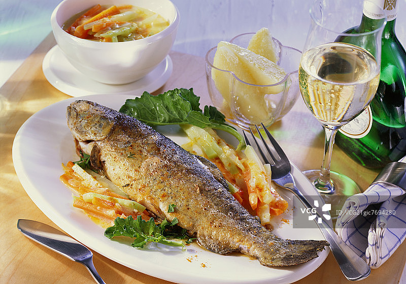 油炸鳟鱼配香草，甘蓝和胡萝卜，白葡萄酒图片素材