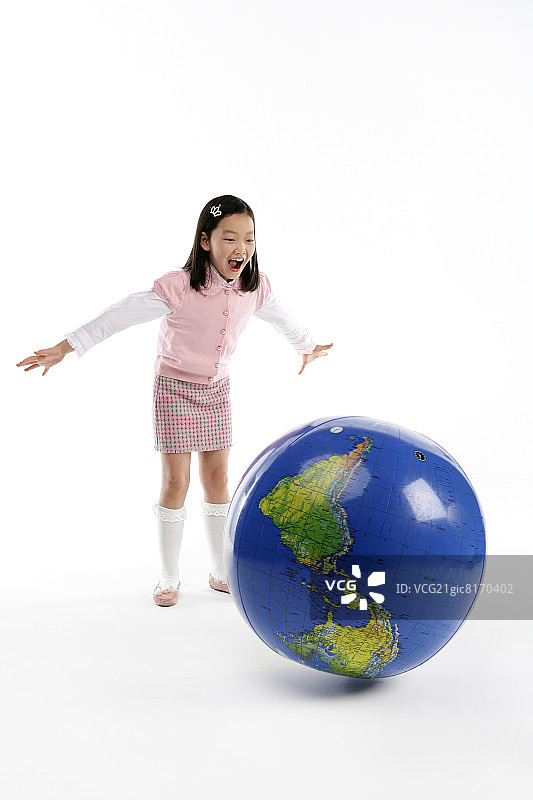 女孩(12-13岁)双臂张开，嘴张着，看着地球图片素材