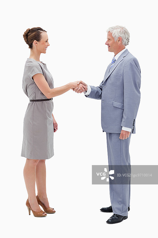 商人与一名女子面对面握手，背景是白人图片素材
