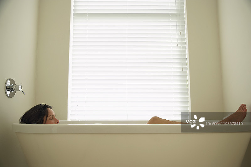 侧视图，躺在浴缸里的女人图片素材