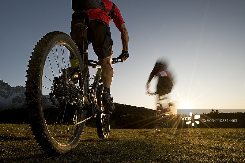 骑山地车的人朝着日落的方向快速前进图片素材