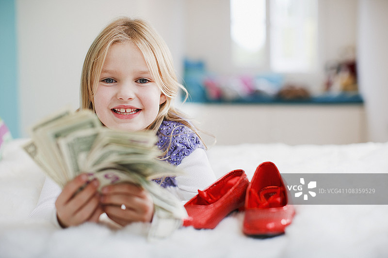 微笑的女孩拿着美元钞票图片素材